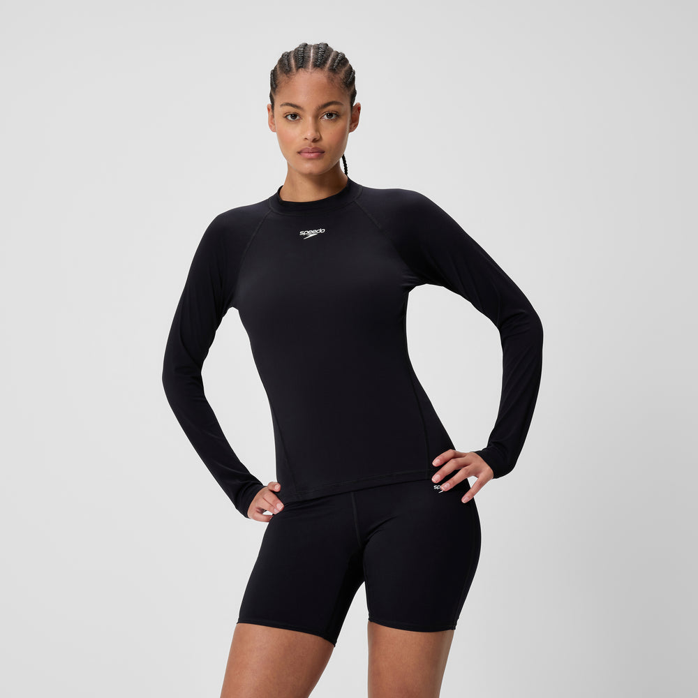 Black long-sleeve rash guard worn with fitted swim shorts
