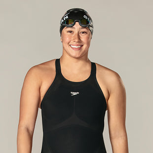 Female swimmer in black suit smiling at camera