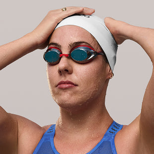 Female swimmer adjusting cap and goggles